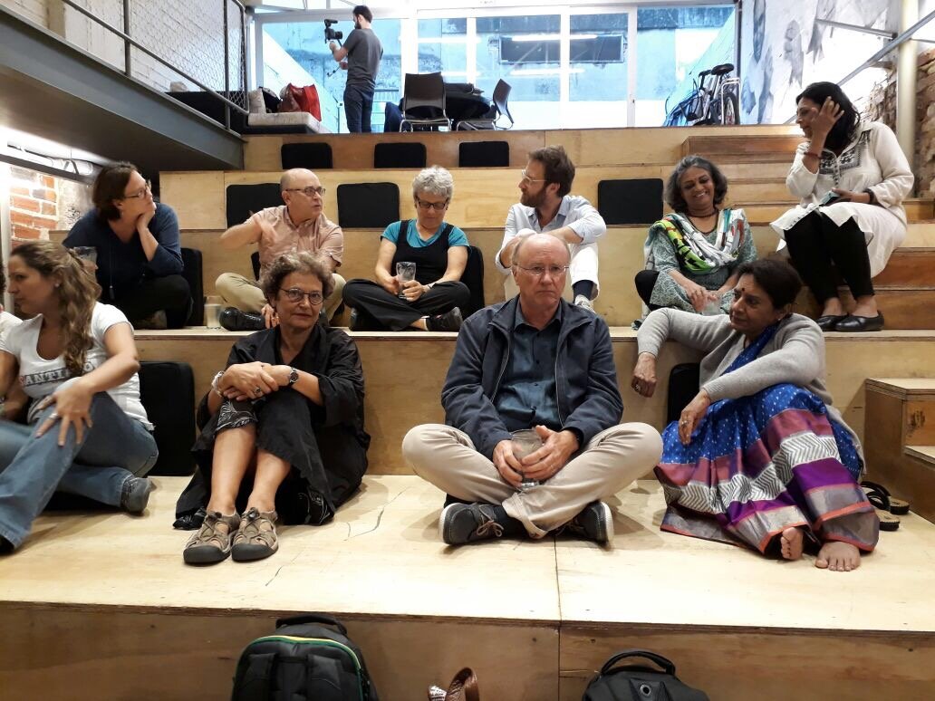 Participants seated on wooden steps during a dialogue