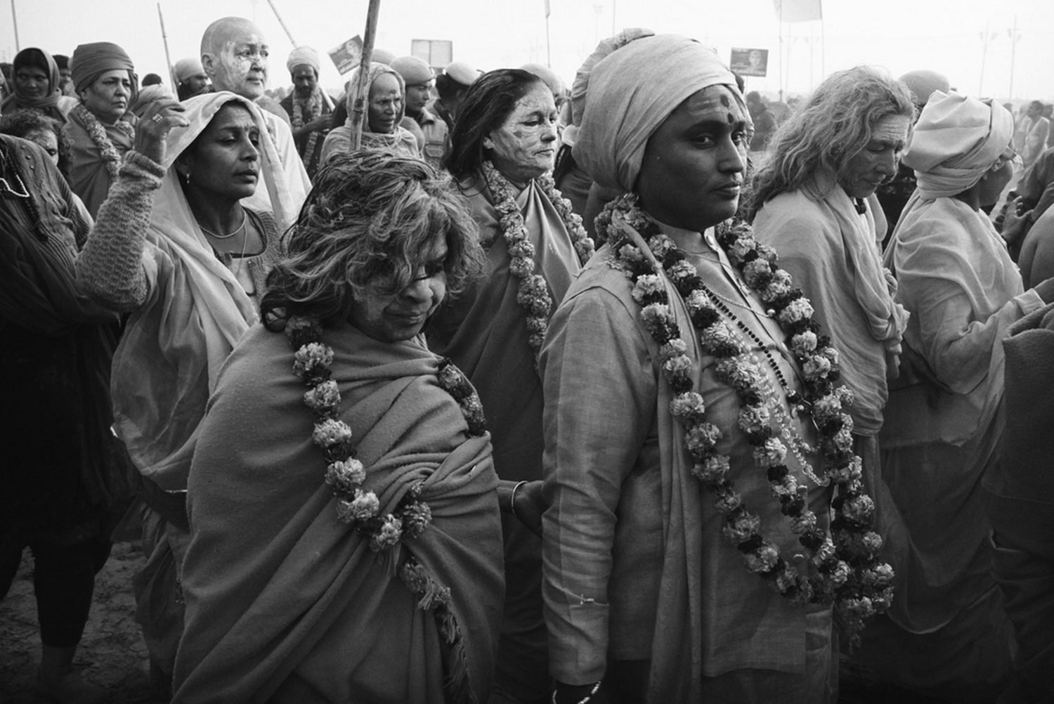 Pilgrims wearing marigold garlands at the Kumbh Mela, in black and white